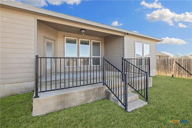 entrance to property with a lawn