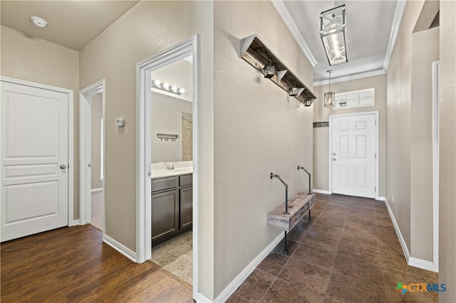 hall featuring dark wood-type flooring, ornamental molding, and sink