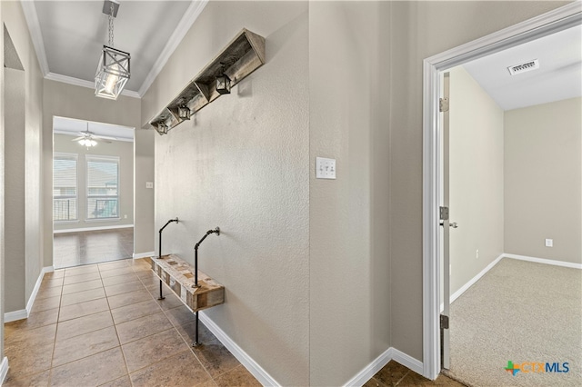 hallway featuring ornamental molding and tile patterned flooring