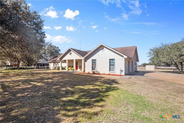 view of front of property featuring a garage, covered porch, and a front yard