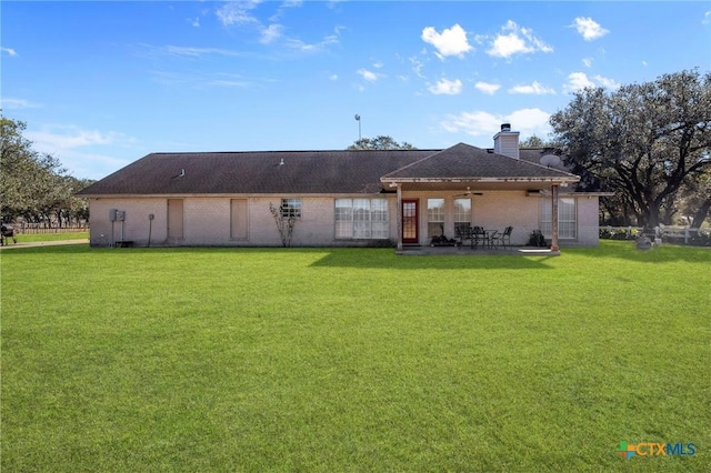 rear view of house with a patio area, ceiling fan, and a lawn