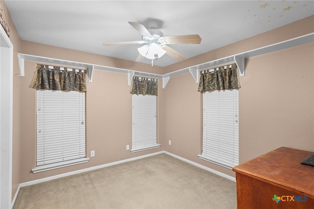 carpeted spare room with ceiling fan