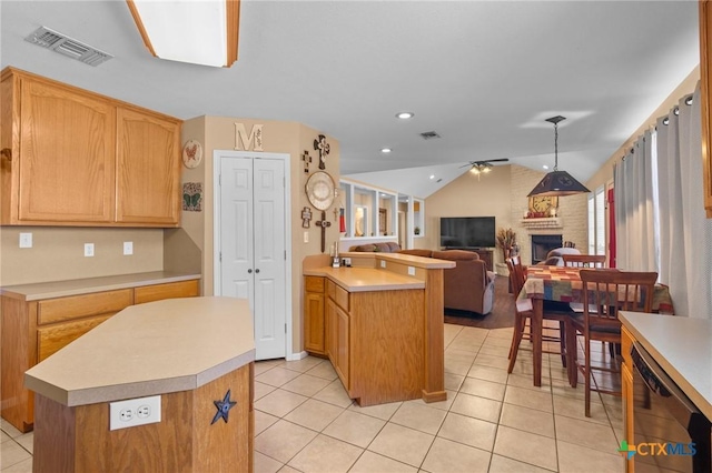 kitchen with lofted ceiling, a brick fireplace, black dishwasher, and a kitchen island