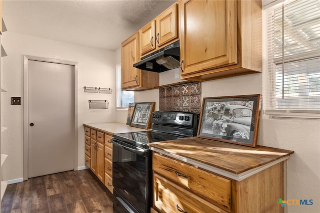 kitchen featuring electric range, a textured ceiling, a healthy amount of sunlight, and dark hardwood / wood-style floors