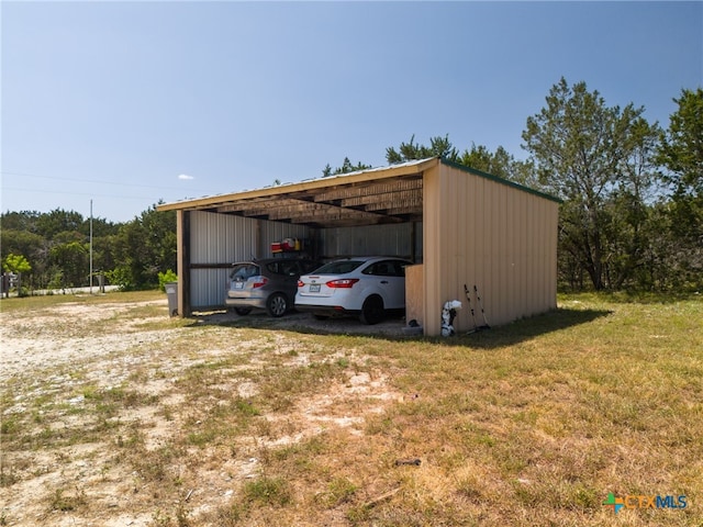 view of outdoor structure with a yard and a carport