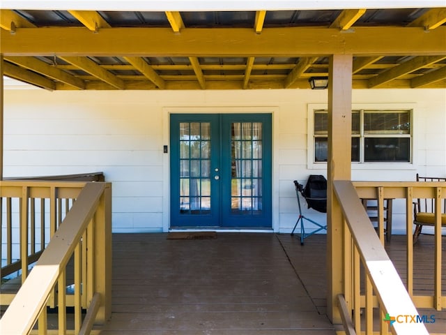 view of exterior entry featuring a deck and french doors