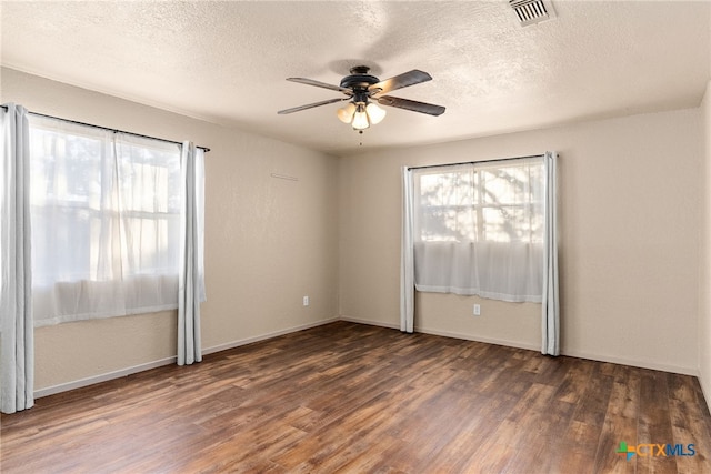 empty room featuring dark hardwood / wood-style flooring, a textured ceiling, and ceiling fan