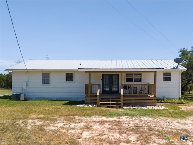 rear view of property with a lawn, french doors, and central AC