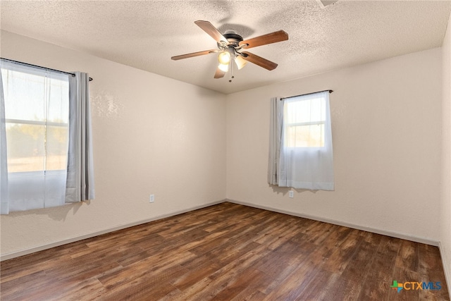 spare room with a textured ceiling, ceiling fan, and dark hardwood / wood-style floors