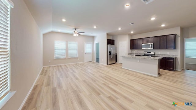 kitchen featuring recessed lighting, a sink, stainless steel appliances, dark brown cabinetry, and open floor plan