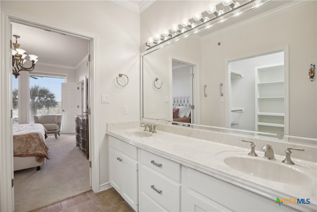 bathroom with a notable chandelier, vanity, and crown molding