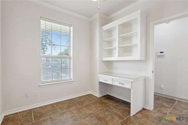 interior space with ceiling fan, built in desk, and ornamental molding