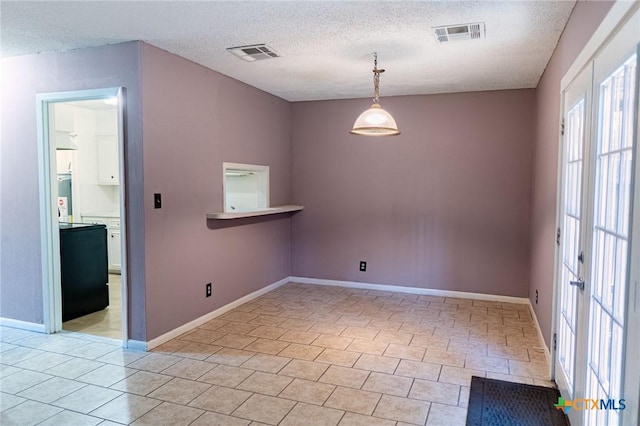 spare room with baseboards, visible vents, a textured ceiling, and light tile patterned flooring