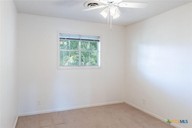 unfurnished room with a ceiling fan, light carpet, visible vents, and baseboards