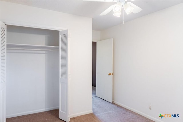 unfurnished bedroom with ceiling fan, carpet floors, a closet, and baseboards