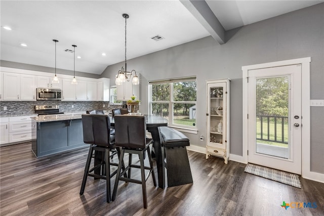 dining space with a chandelier, dark hardwood / wood-style flooring, lofted ceiling with beams, and a healthy amount of sunlight