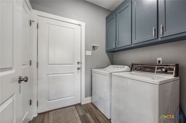 laundry area featuring washer and dryer, dark hardwood / wood-style floors, and cabinets