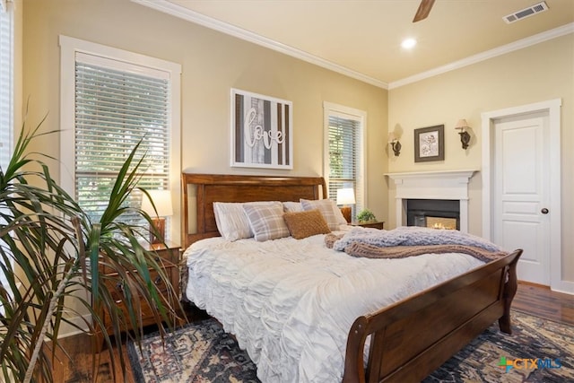 bedroom with multiple windows, crown molding, dark hardwood / wood-style flooring, and ceiling fan