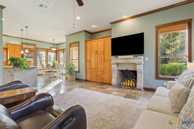 living room featuring ceiling fan, ornamental molding, and a premium fireplace