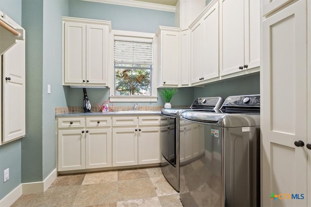 laundry room featuring crown molding, cabinets, independent washer and dryer, and sink