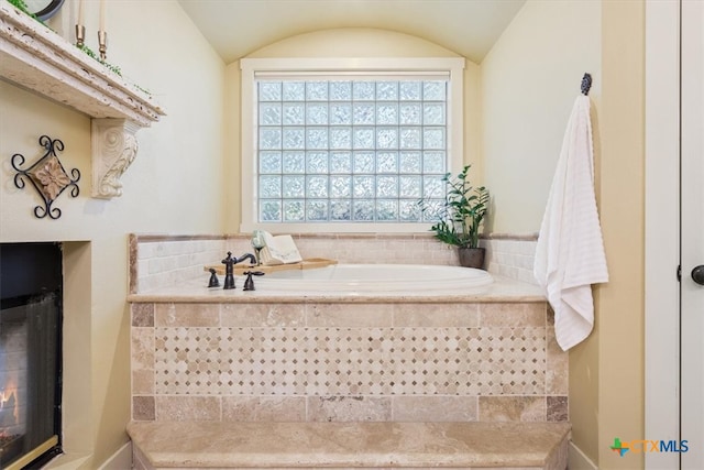 bathroom with tiled bath and vaulted ceiling