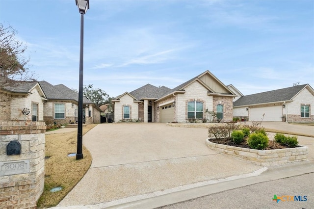 french country inspired facade with concrete driveway and an attached garage