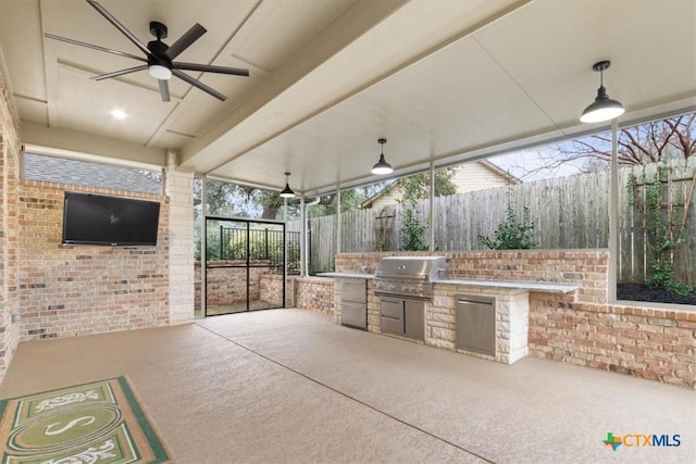 view of patio featuring grilling area, ceiling fan, and exterior kitchen