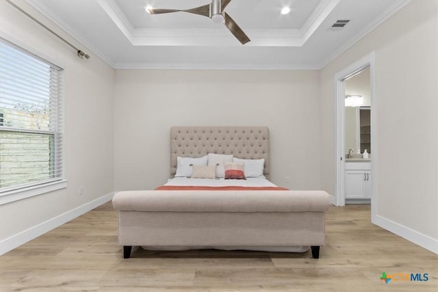 bedroom with a tray ceiling, crown molding, visible vents, and light wood-type flooring