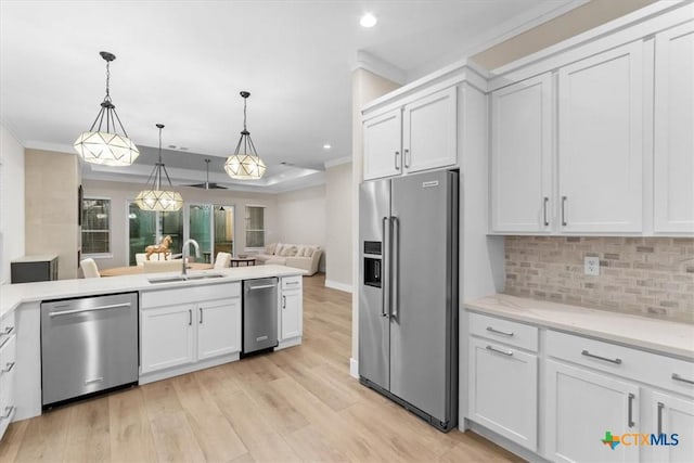 kitchen with backsplash, open floor plan, ornamental molding, stainless steel appliances, and a sink