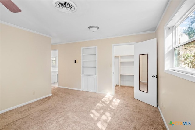 unfurnished bedroom with ornamental molding, light colored carpet, ceiling fan, and multiple windows