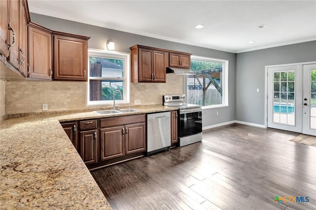 214 Hubbard St, Yoakum, TX 77995 - kitchen with stainless steel appliances, a sink, under cabinet range hood, plenty of natural light, and ornamental molding