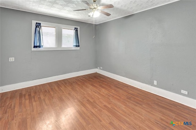 214 Hubbard St, Yoakum, TX 77995 - spare room with a ceiling fan, wood finished floors, and baseboards