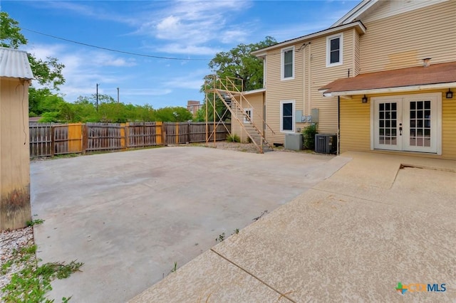 214 Hubbard St, Yoakum, TX 77995 - fenced backyard featuring french doors, a patio area, cooling unit, and stairs