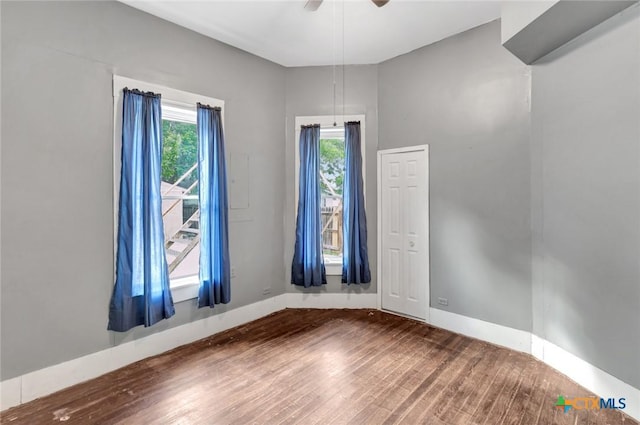 214 Hubbard St, Yoakum, TX 77995 - unfurnished room with wood finished floors, plenty of natural light, and baseboards