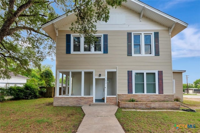 214 Hubbard St, Yoakum, TX 77995 - view of front of home featuring a front yard and brick siding
