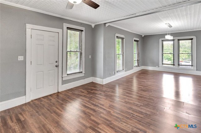 214 Hubbard St, Yoakum, TX 77995 - entrance foyer featuring ornamental molding, healthy amount of natural light, baseboards, and dark wood-type flooring