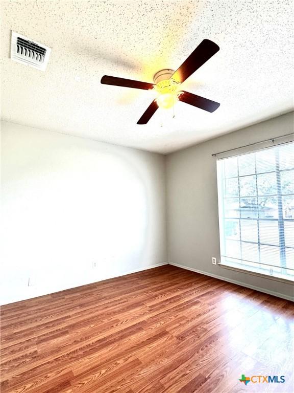 6430 Ridge Village Dr, San Antonio, TX 78233 - spare room with a ceiling fan, wood finished floors, and a textured ceiling