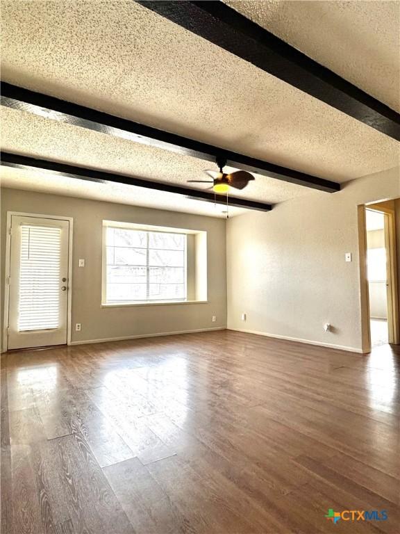 6430 Ridge Village Dr, San Antonio, TX 78233 - unfurnished living room featuring a textured ceiling, wood finished floors, beamed ceiling, a ceiling fan, and baseboards