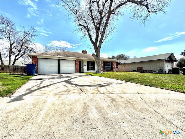 single story home with a garage, a chimney, fence, a front lawn, and brick siding