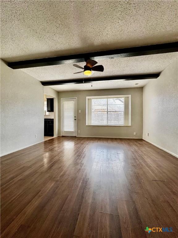 6430 Ridge Village Dr, San Antonio, TX 78233 - unfurnished living room with a textured ceiling, dark wood-type flooring, beam ceiling, and ceiling fan