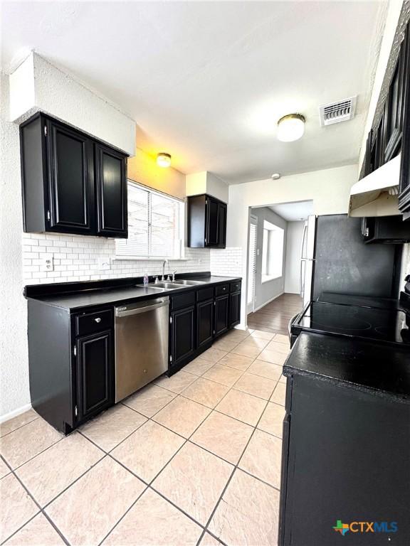 6430 Ridge Village Dr, San Antonio, TX 78233 - kitchen with dishwasher, dark cabinets, and decorative backsplash