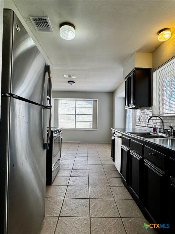 6430 Ridge Village Dr, San Antonio, TX 78233 - kitchen featuring stainless steel appliances, a sink, dark cabinets, and healthy amount of natural light
