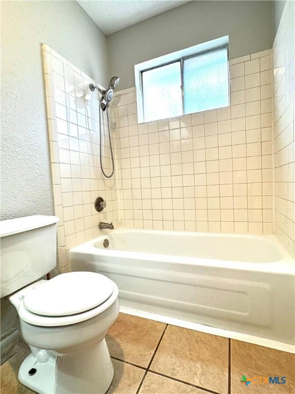 6430 Ridge Village Dr, San Antonio, TX 78233 - bathroom featuring tile patterned flooring, toilet, and shower / bath combination