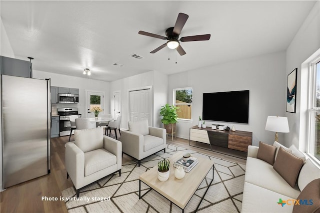 living room featuring ceiling fan and light hardwood / wood-style floors