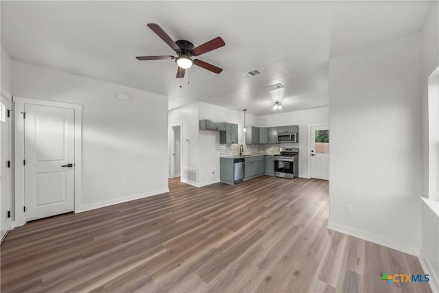 unfurnished living room with dark hardwood / wood-style floors, ceiling fan, and sink