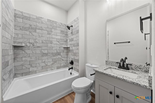 full bathroom with hardwood / wood-style flooring, vanity, toilet, and tiled shower / bath