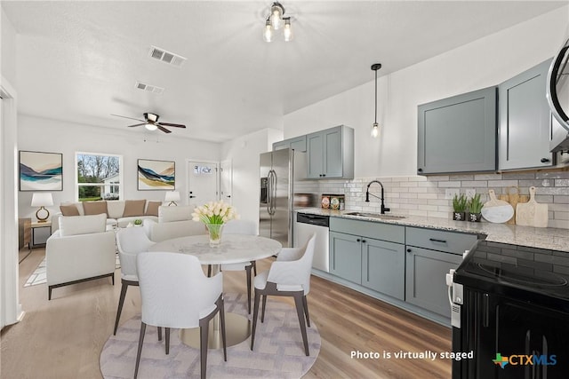 dining area featuring hardwood / wood-style flooring, ceiling fan, and sink