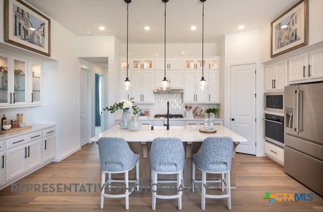 kitchen featuring wall oven, white cabinets, built in microwave, and high end fridge