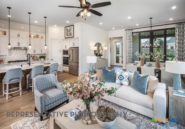 living area with light wood finished floors, recessed lighting, and ceiling fan