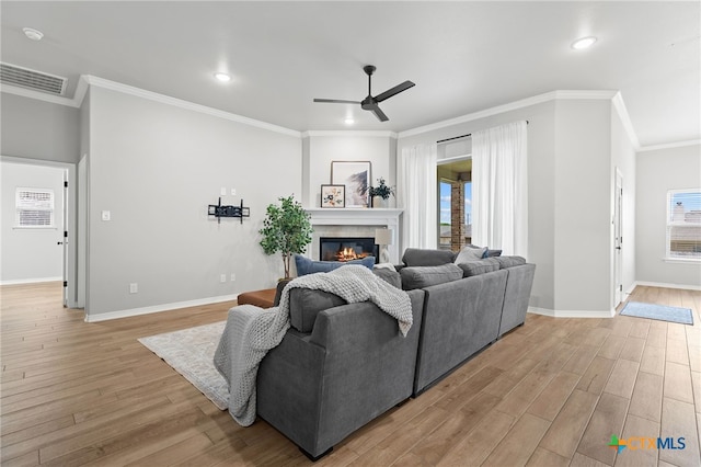 1827 Broken Shoe Trl, Temple, TX 76502 - living area with light wood-type flooring, ceiling fan, a glass covered fireplace, crown molding, and recessed lighting